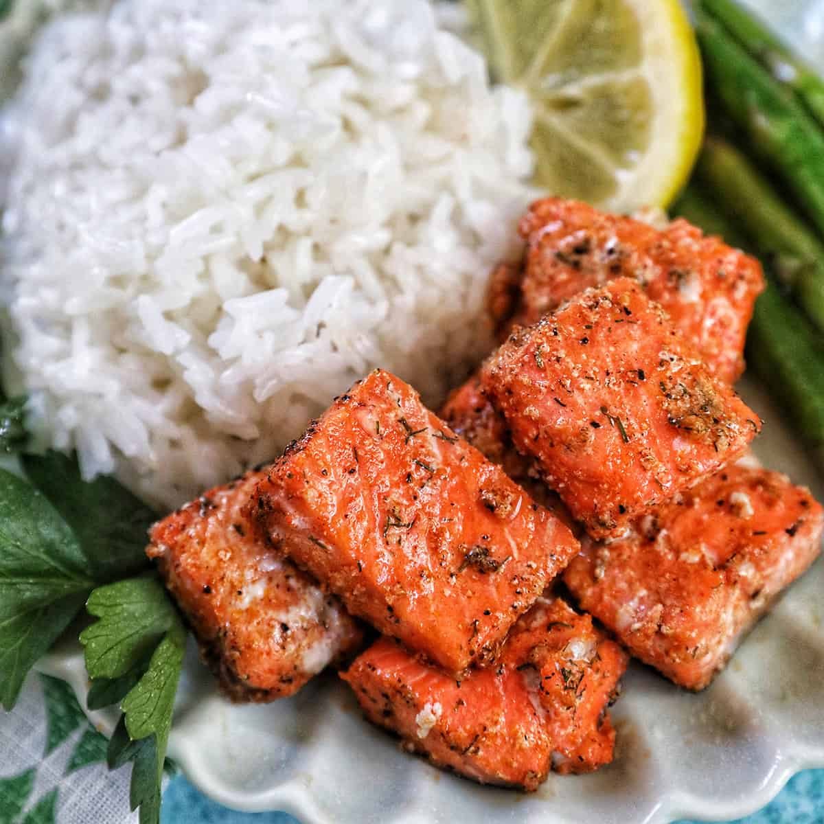 air fryer salmon bites with white rice, asparagus, and lemon slice.