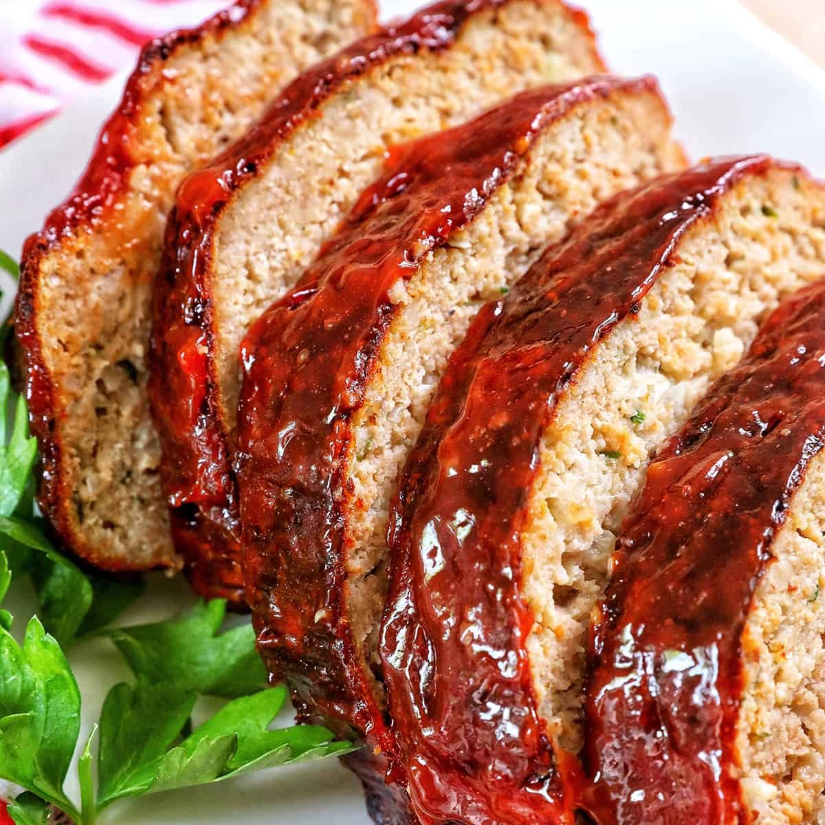 glazed slices of air fryer meatloaf with greens.