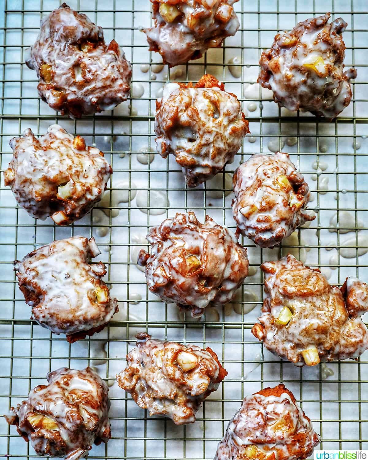 glazed apple fritter donuts on a wire rack.