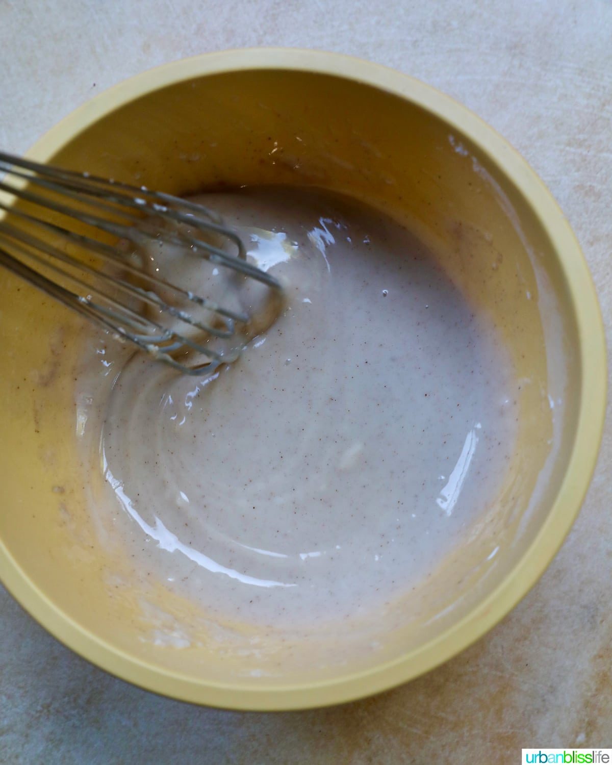 yellow bowl with cinnamon glaze for apple fritters.