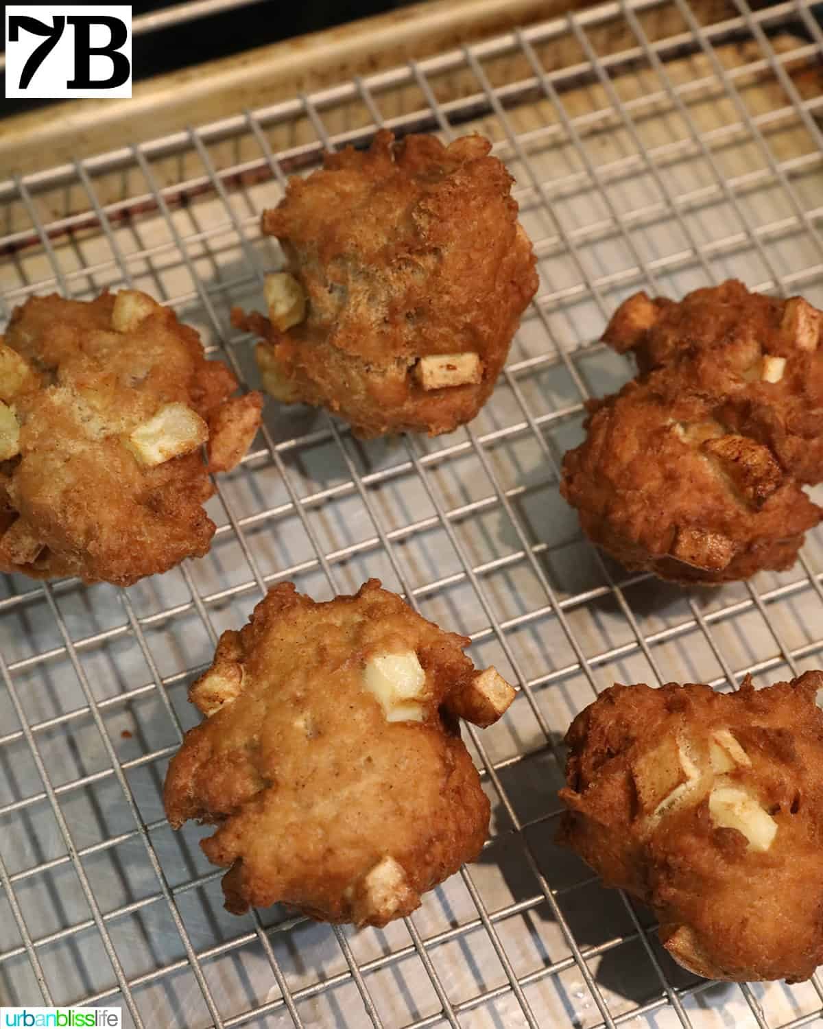 hot apple fritter donuts on a wire rack.