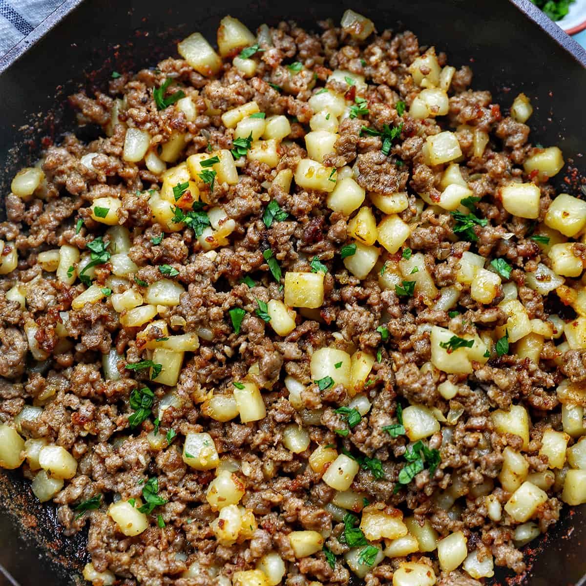 breakfast sausage potato hash in a cast iron skillet.