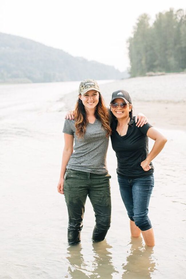 two women standing in river