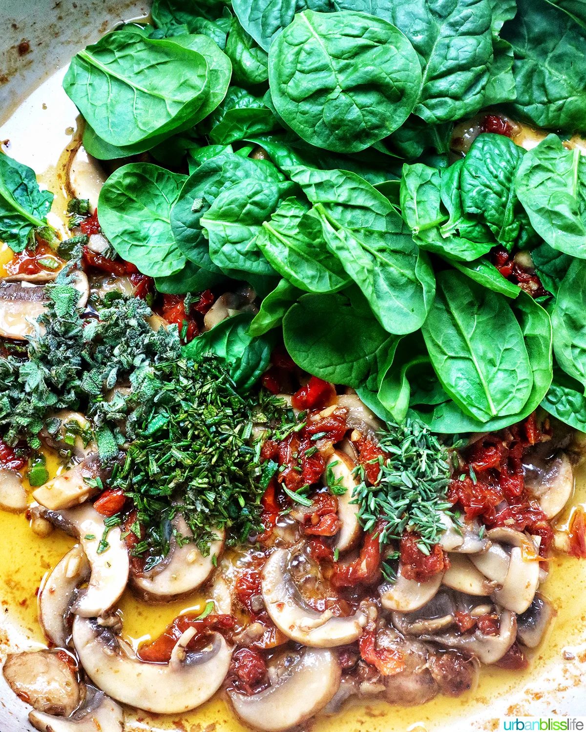 spinach, mushrooms, herbs in a pan with olive oil.