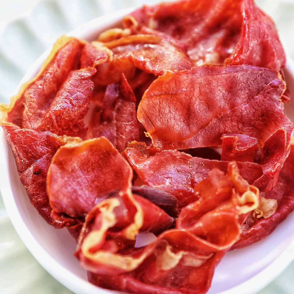 crispy prosciutto in a small white bowl.
