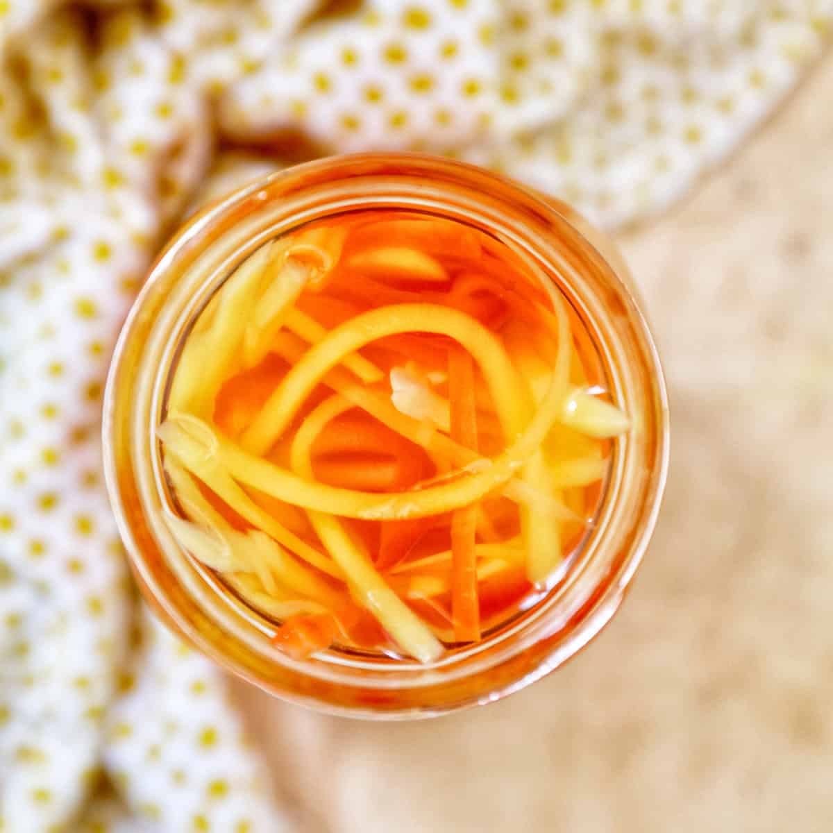 mason jar with Filipino atchara condiment - papaya, carrots, red bell pepper, garlic, ginger.