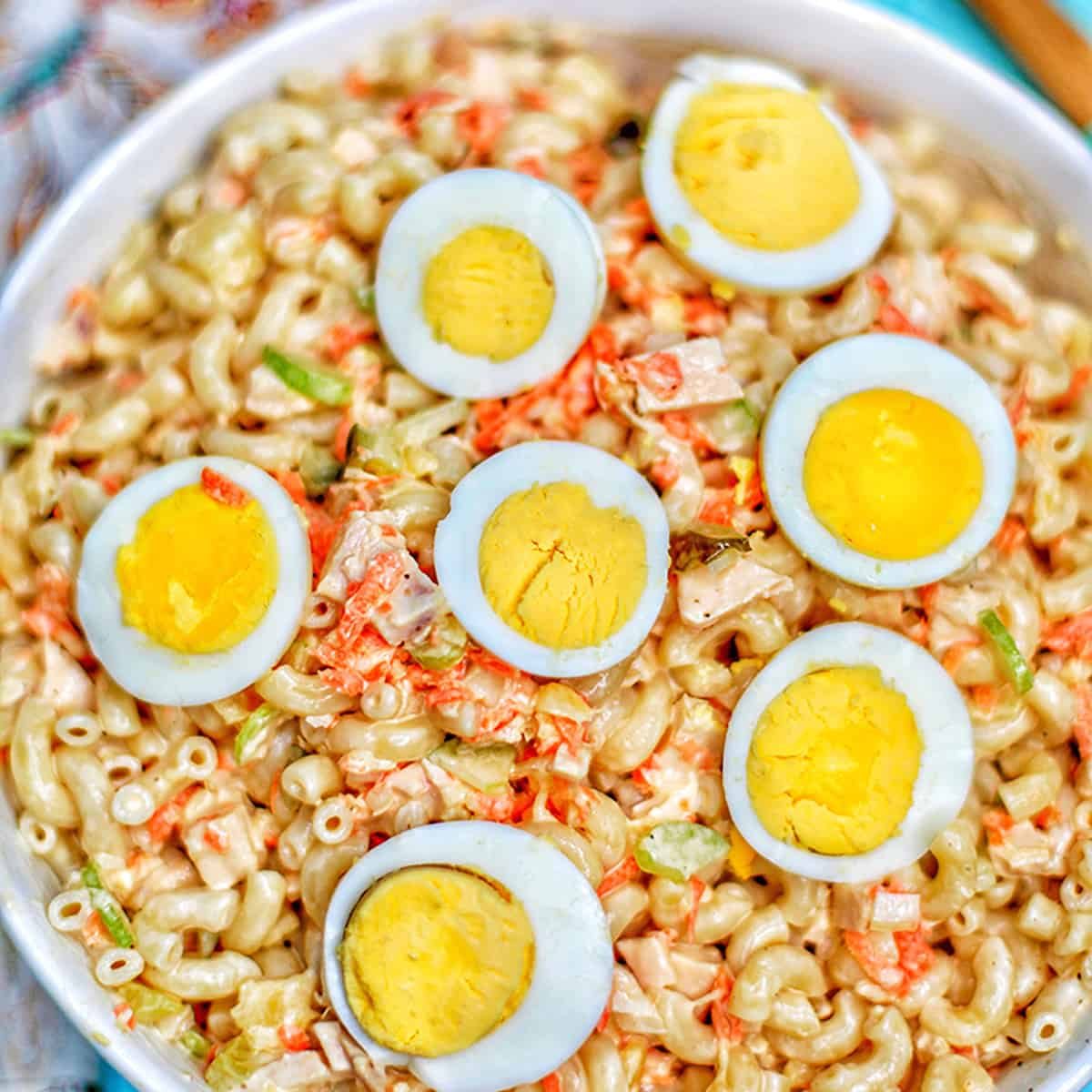 filipino macaroni salad with hard boiled egg halves in bowl.