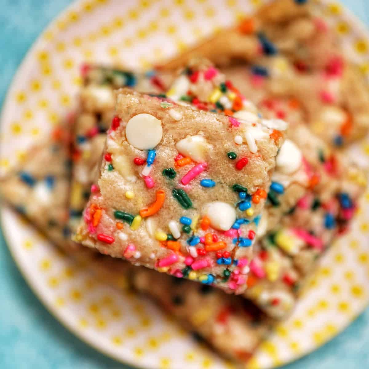 funfetti dessert bars stacked on a plate.