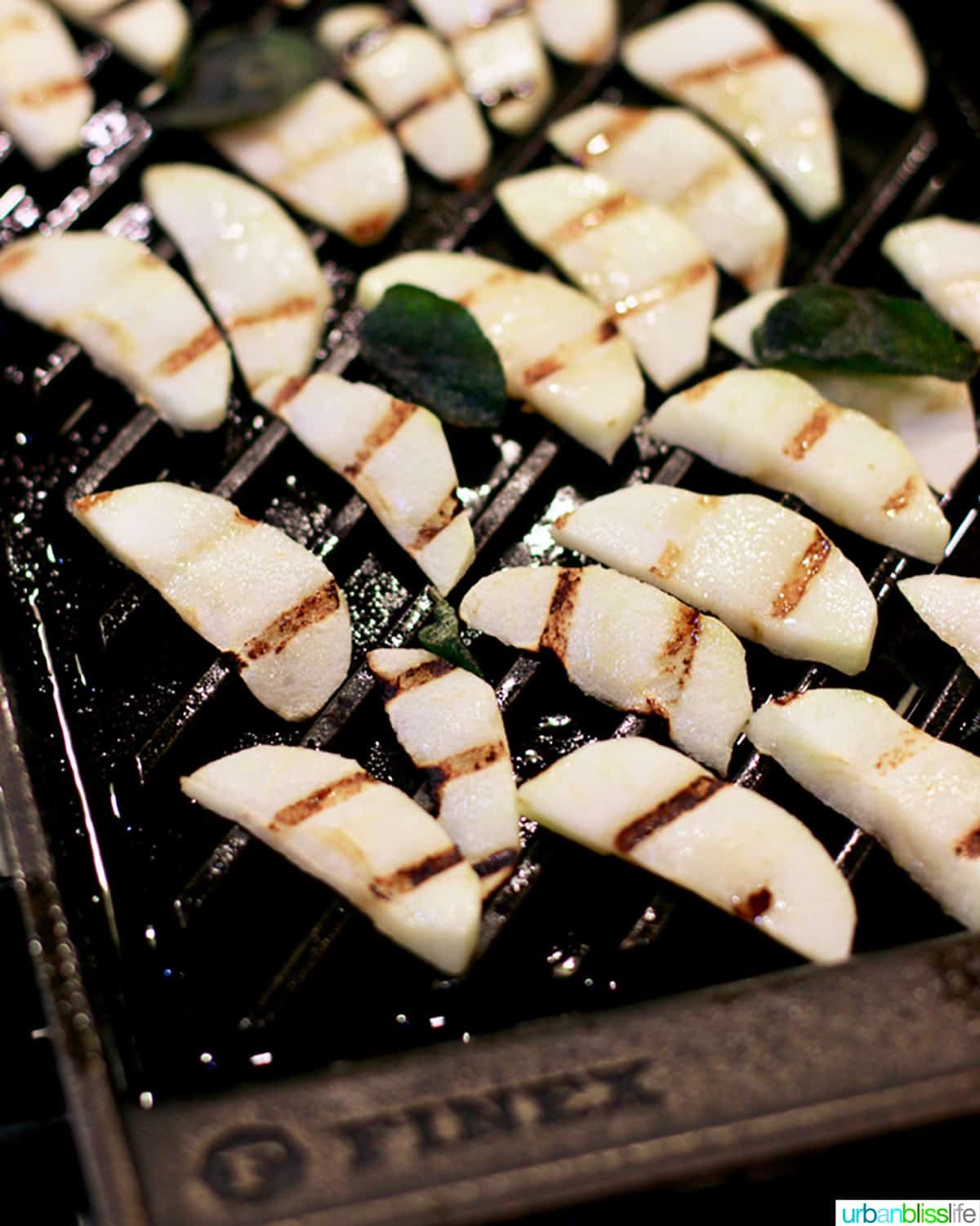 sliced apples with grill marks on a grill pan.