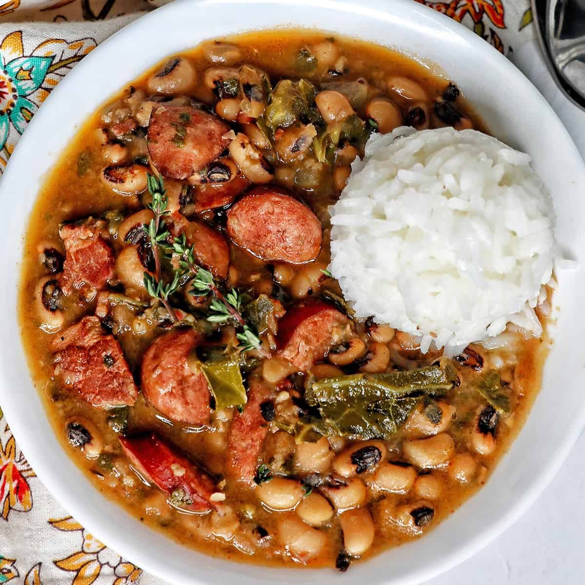 Pressure-cooker black eyes peas with scoop of white rice in a white bowl.