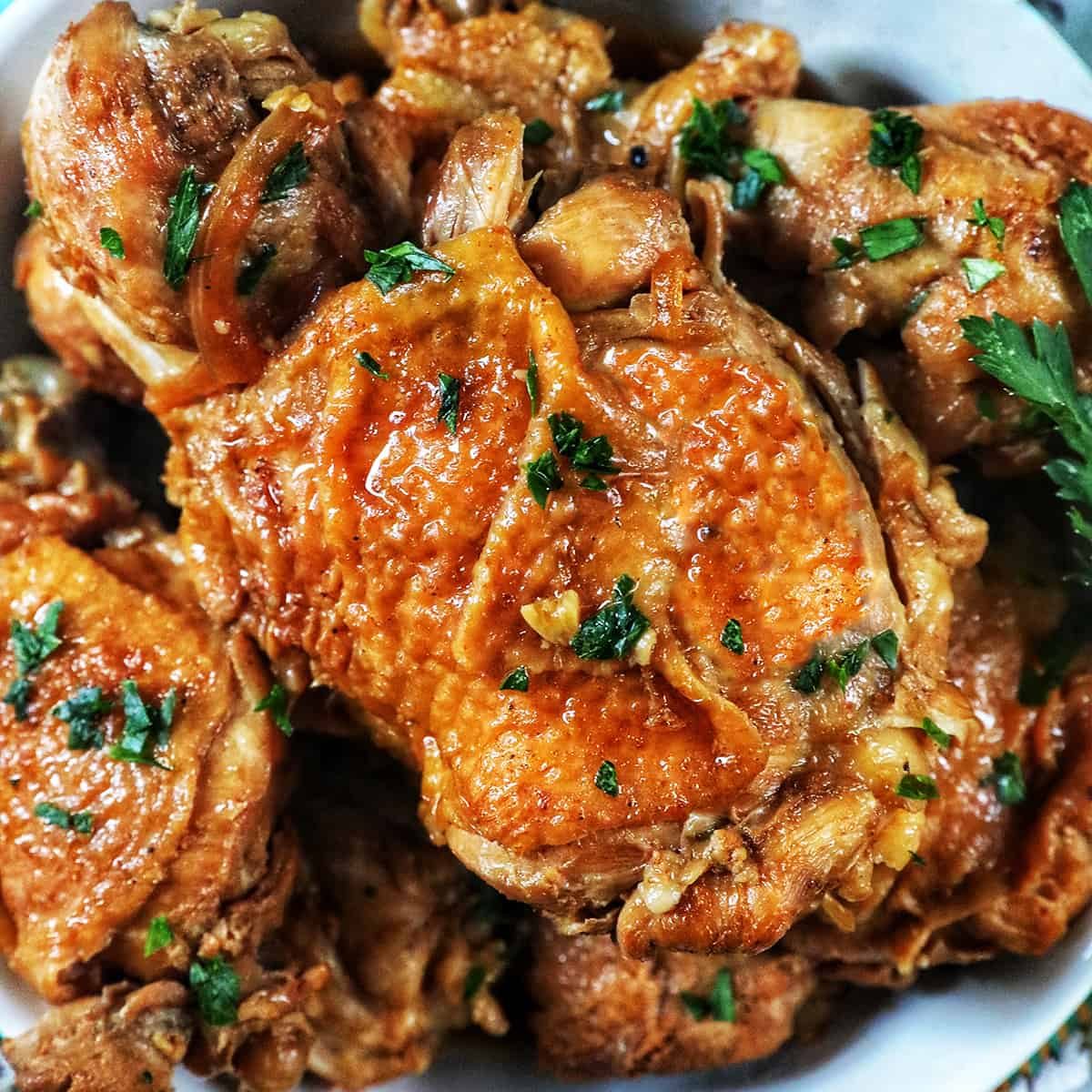 bowl of Pressure-cooker Filipino Chicken Adobo with herbs.