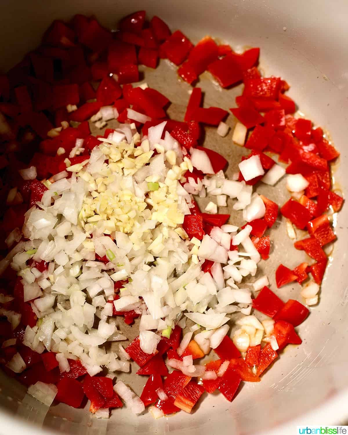 adding peppers, onions, garlic to the ninja foodi