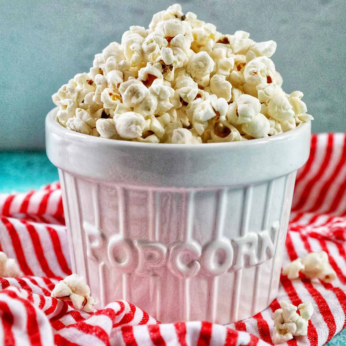 white popcorn bowl full of Pressure-cooker Popcorn on a red and white napkin.