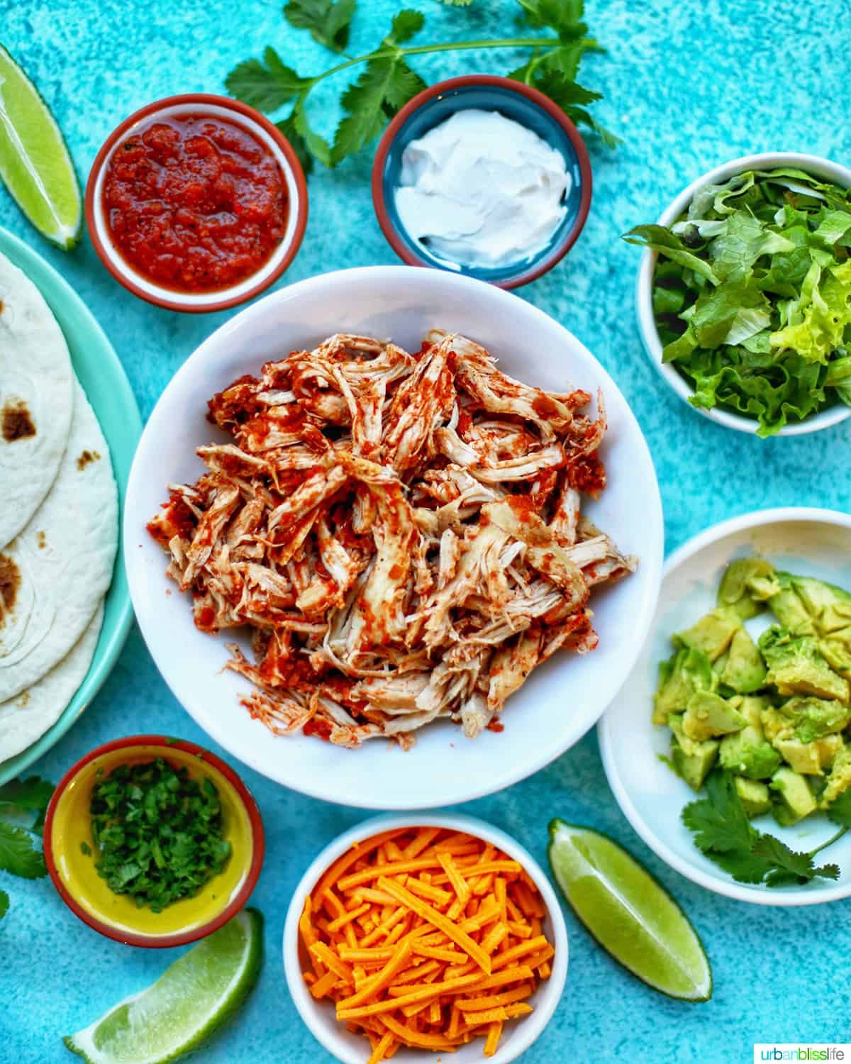 Pressure-cooker Salsa Chicken with salsa, sour cream, cheese, and other toppings for tacos