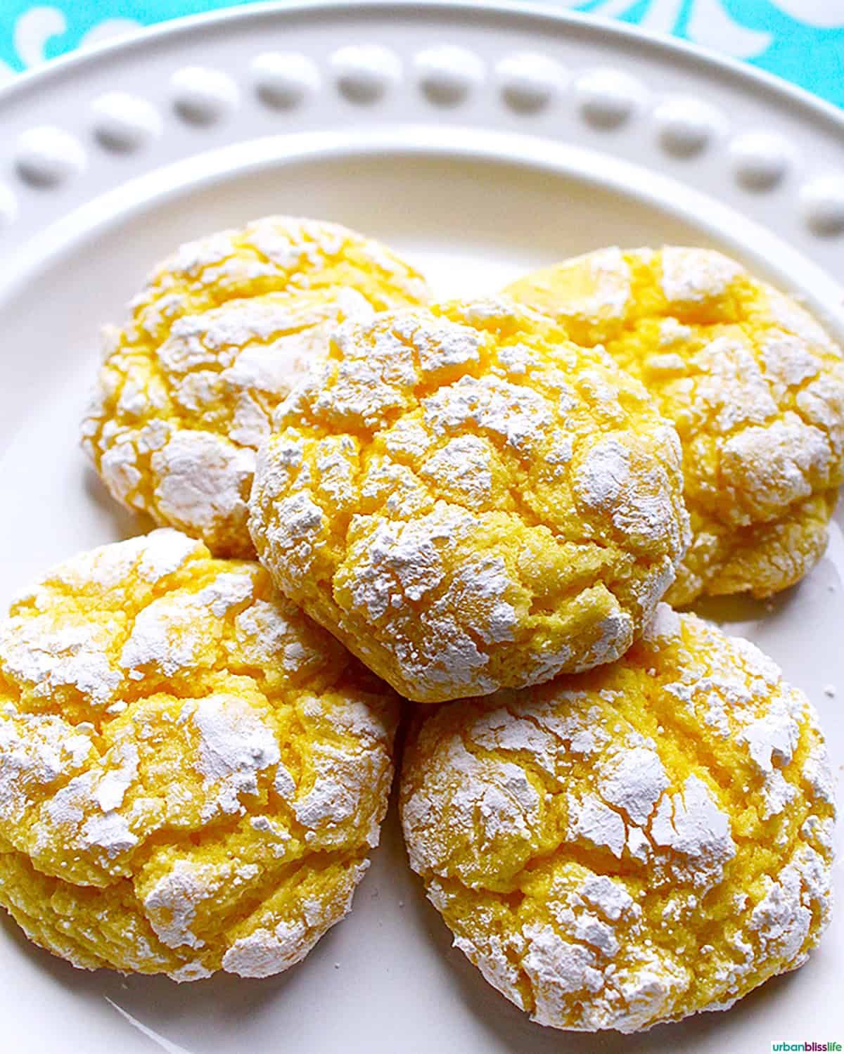 stack of lemon crinkles cookies on a white plate.