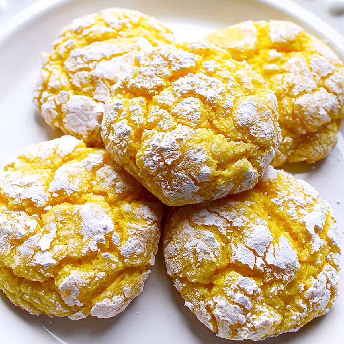 stack of lemon crinkles cookies on a white plate.