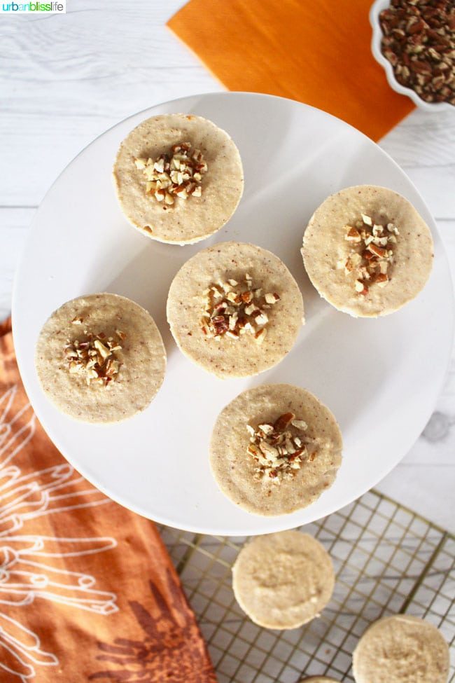 5 no bake cheesecake bites on a white plate with more in the background.