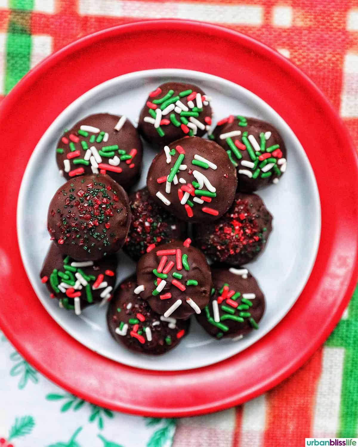 oreo truffles with red, white, and green sprinkles in a Christmas table setting.