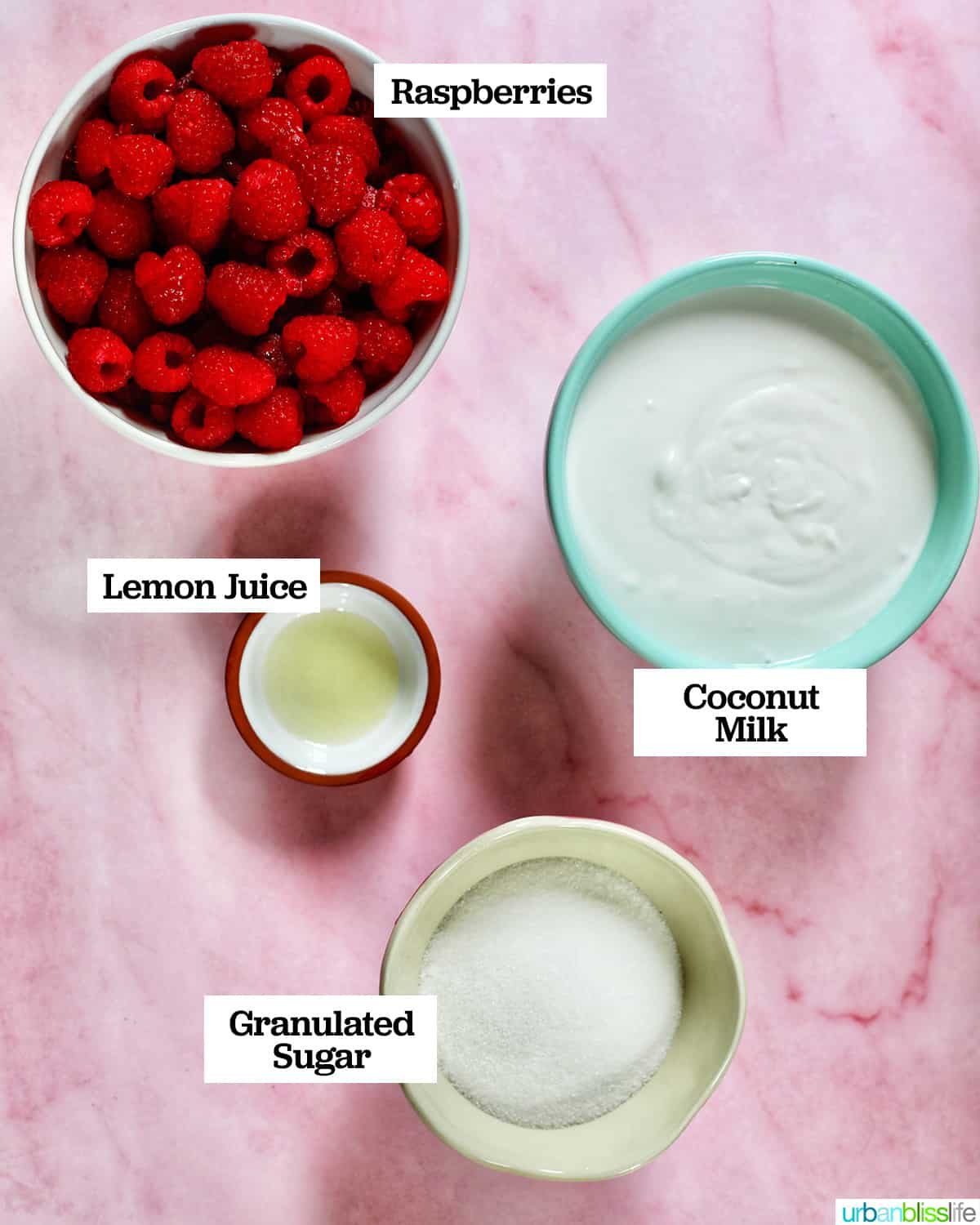 bowls with ingredients to make raspberry sherbet, on top of a pink table.