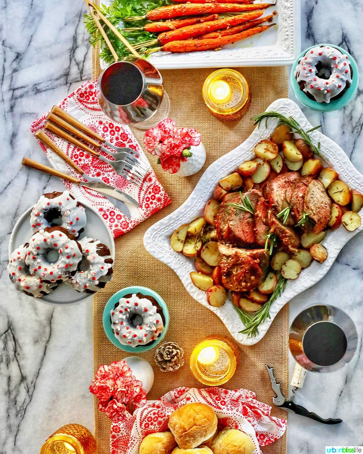 simple holiday meal at home - beef roast, carrots, rolls, glasses of wine, and plates of cake