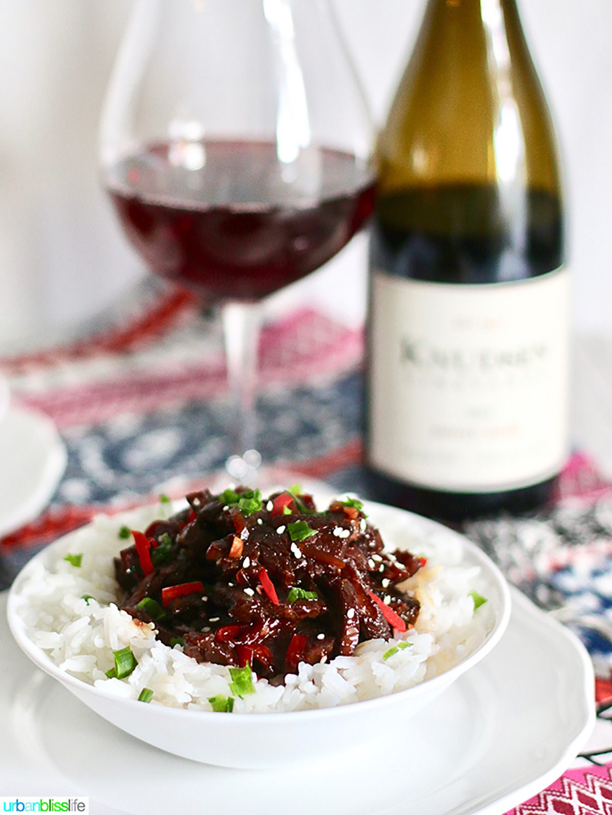 mongolian beef with rice and bottle of red wine