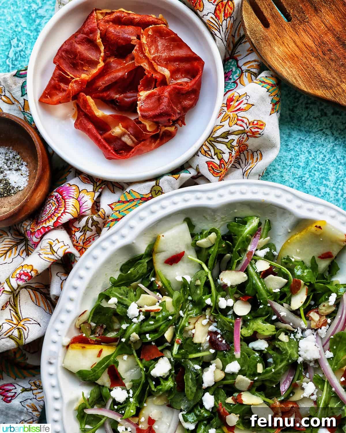 Sweet Pear and Peppery Arugula Salad 12 Bowl of pear arugula salad with a separate bowl of crispy prosciutto positioned above it.