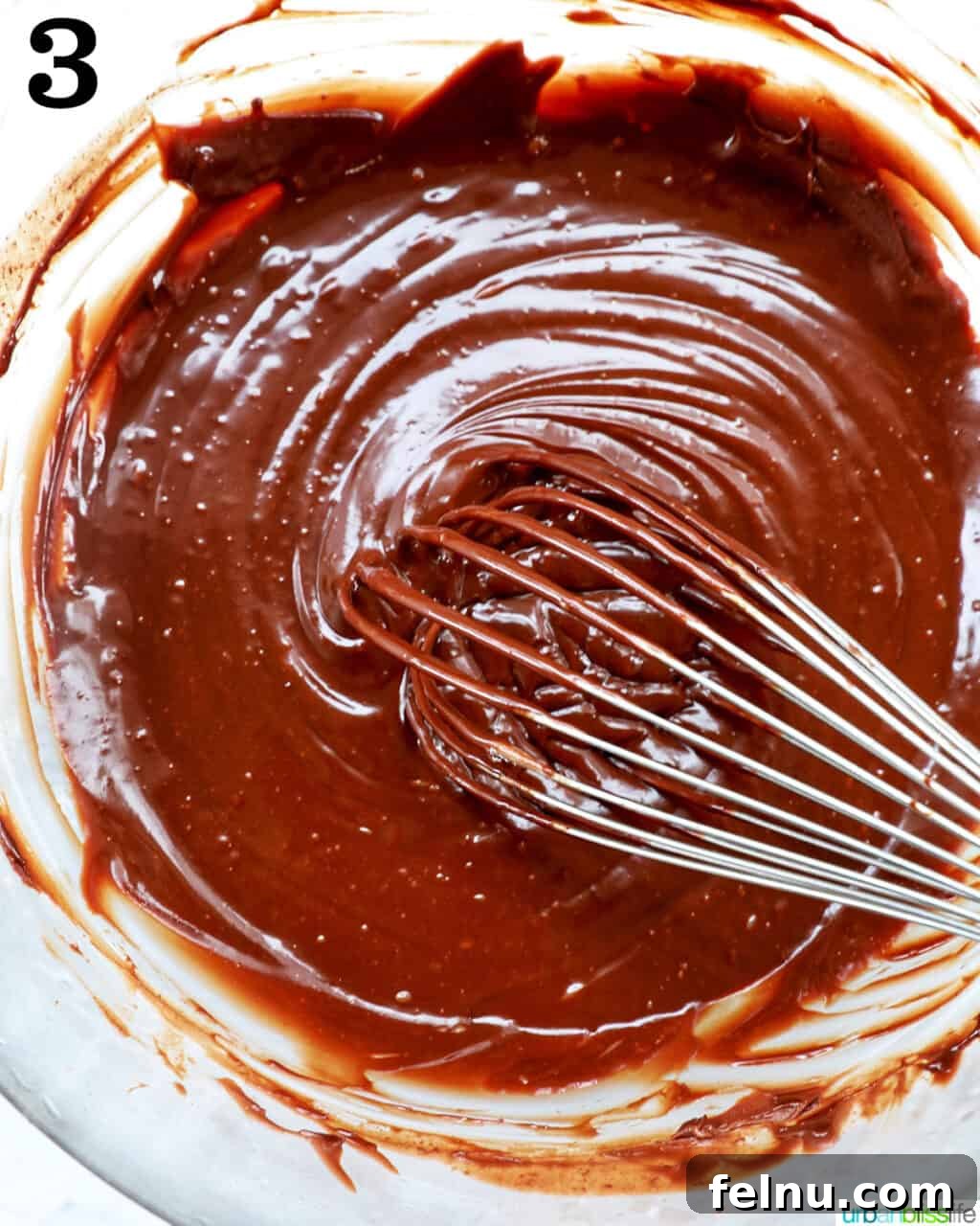 Velvet Chocolate Fudge Cupcakes 7 whisk with chocolate ganache in a bowl.