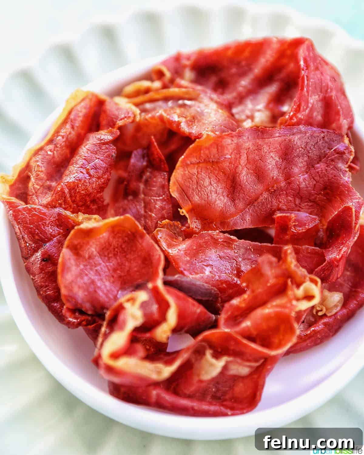 Crispy prosciutto in a small white bowl.