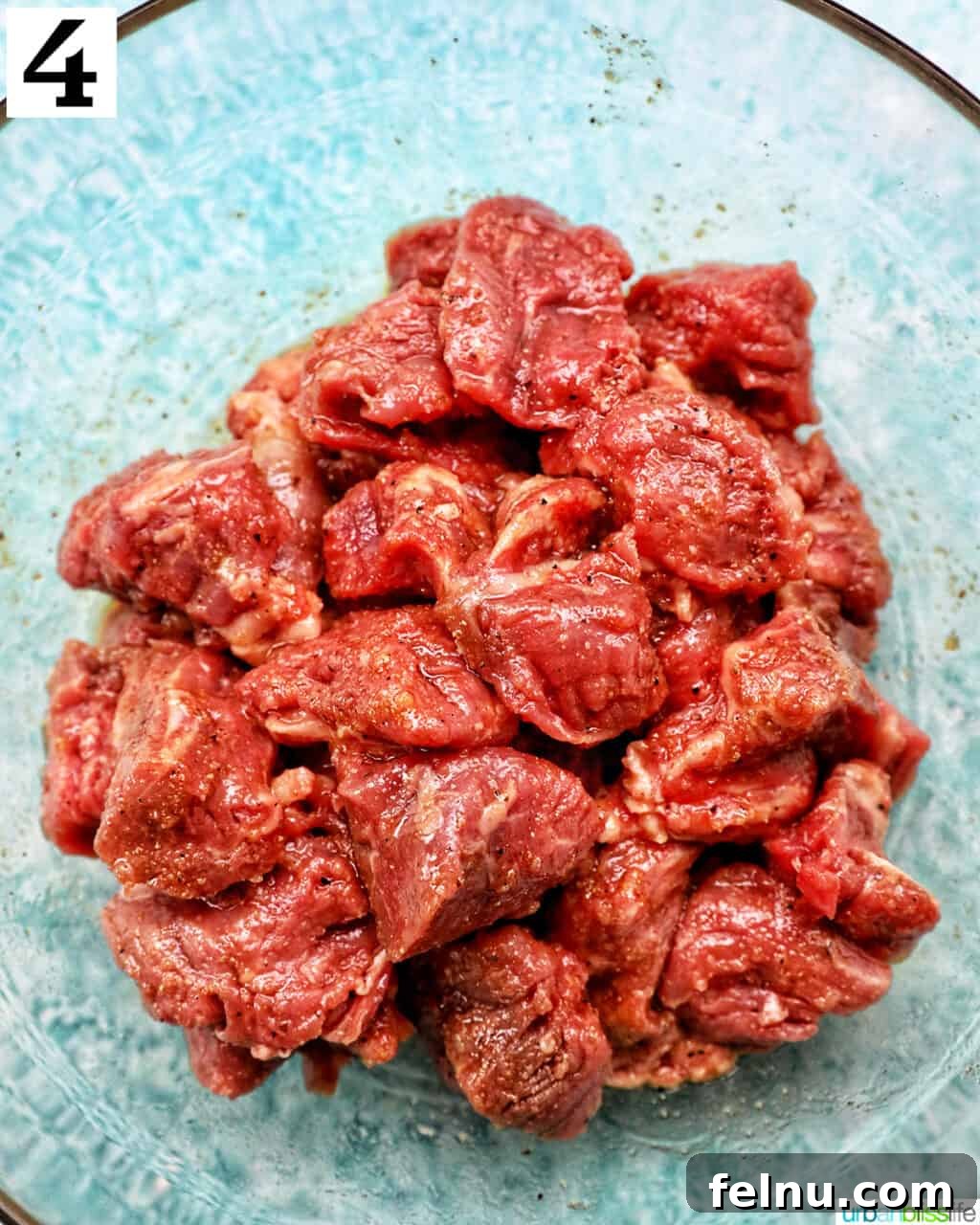 Effortless Air Fryer Steak Morsels 9 steak tips seasoned in a glass bowl.