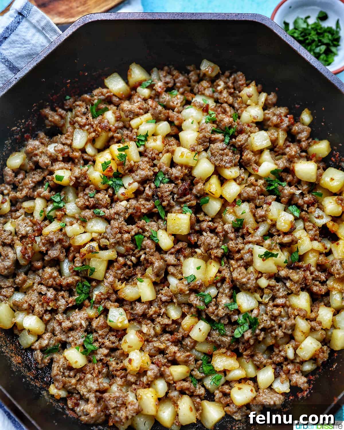 Sizzling Sausage Potato Hash 2 A cast iron skillet filled with savory breakfast sausage potato hash, ready to be served.