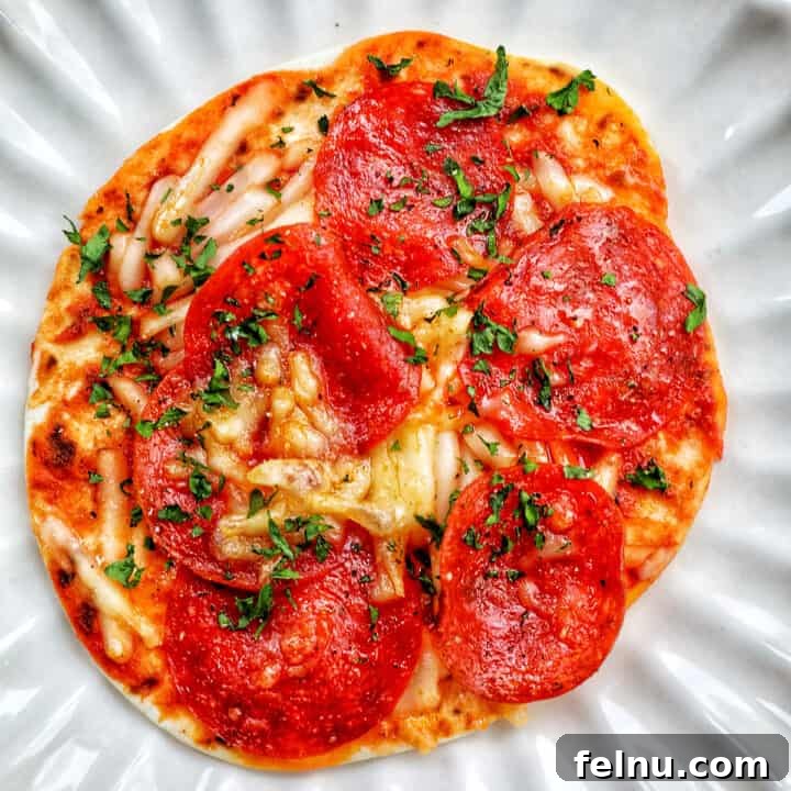 air fryer mini pepperoni pizza on a scalloped plate.