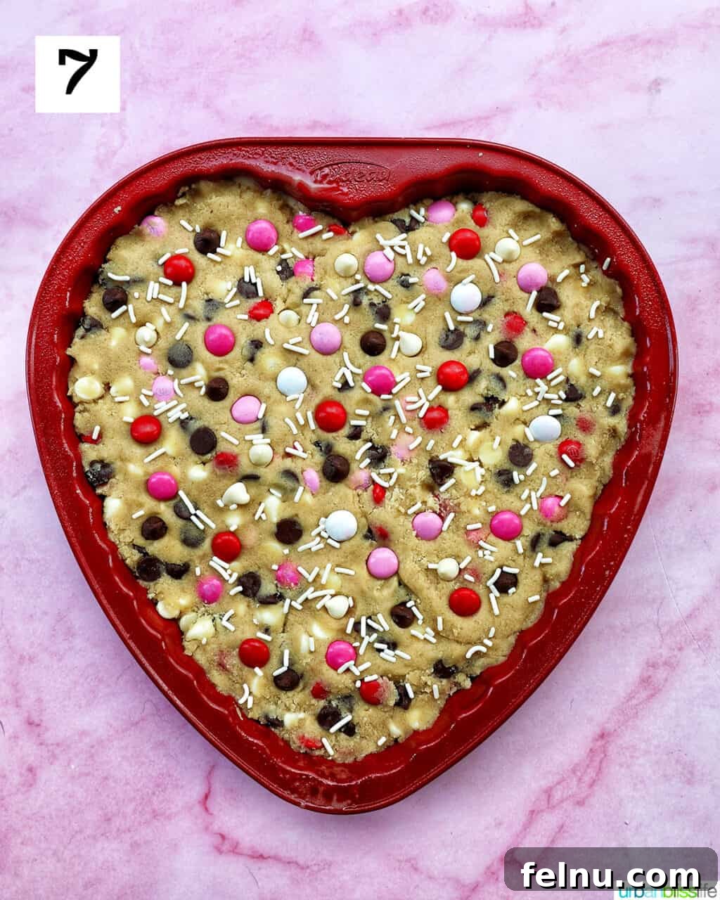 Love Struck Cookie Cake 14 A heart-shaped Valentine's Day cookie cake with red, white, and pink M & M decorations.