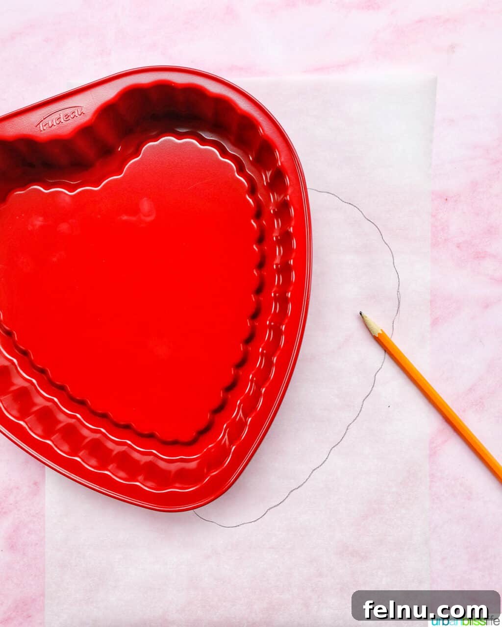 Love Struck Cookie Cake 5 red heart-shaped baking pan over parchment paper and a pencil.