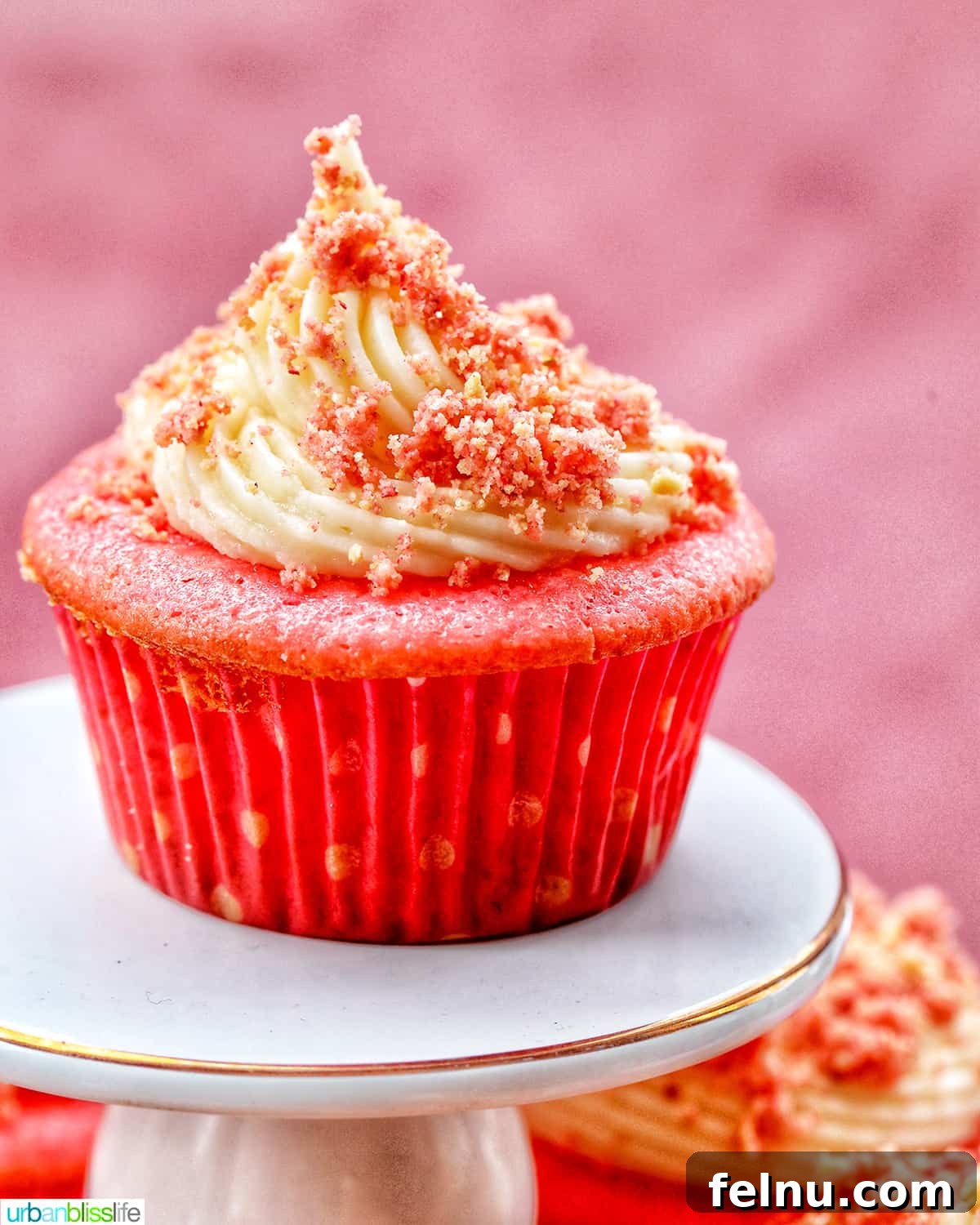 Strawberry Shortcake Crunch Cupcakes 2 A perfectly frosted strawberry crunch cupcake on a pristine white pedestal, highlighting its vibrant colors and inviting texture.
