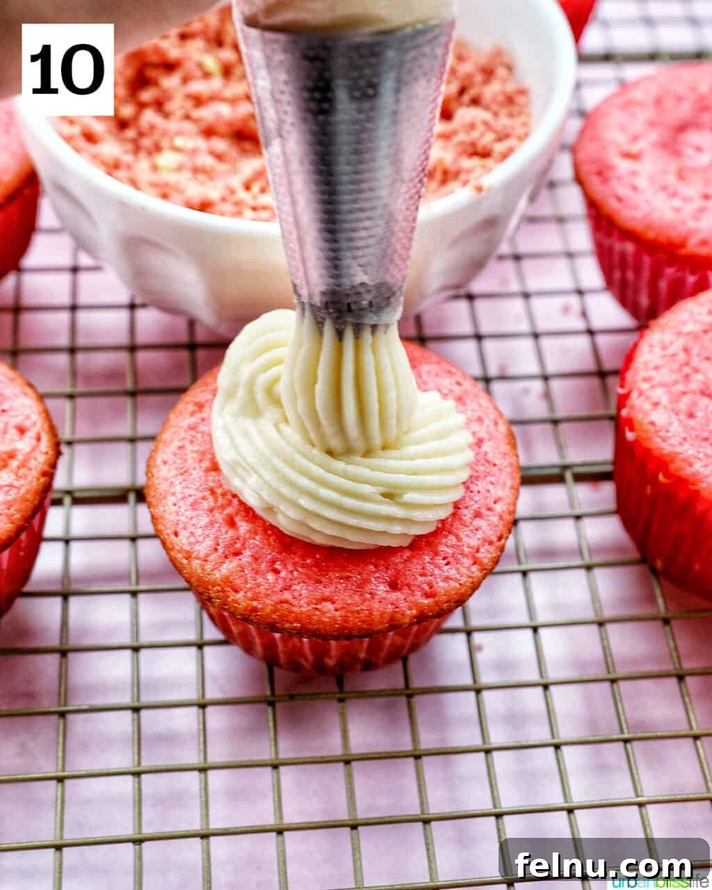 Strawberry Shortcake Crunch Cupcakes 21 Vanilla buttercream being piped onto a cooled strawberry cupcake.