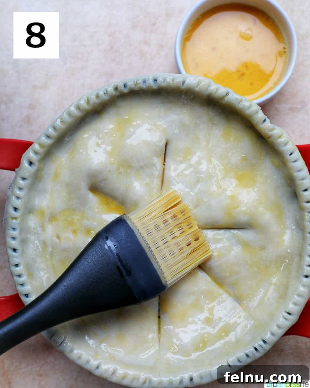 Flaky Air Fryer Chicken Pot Pie 15 pastry brush brushing egg wash over an unbaked pie crust.