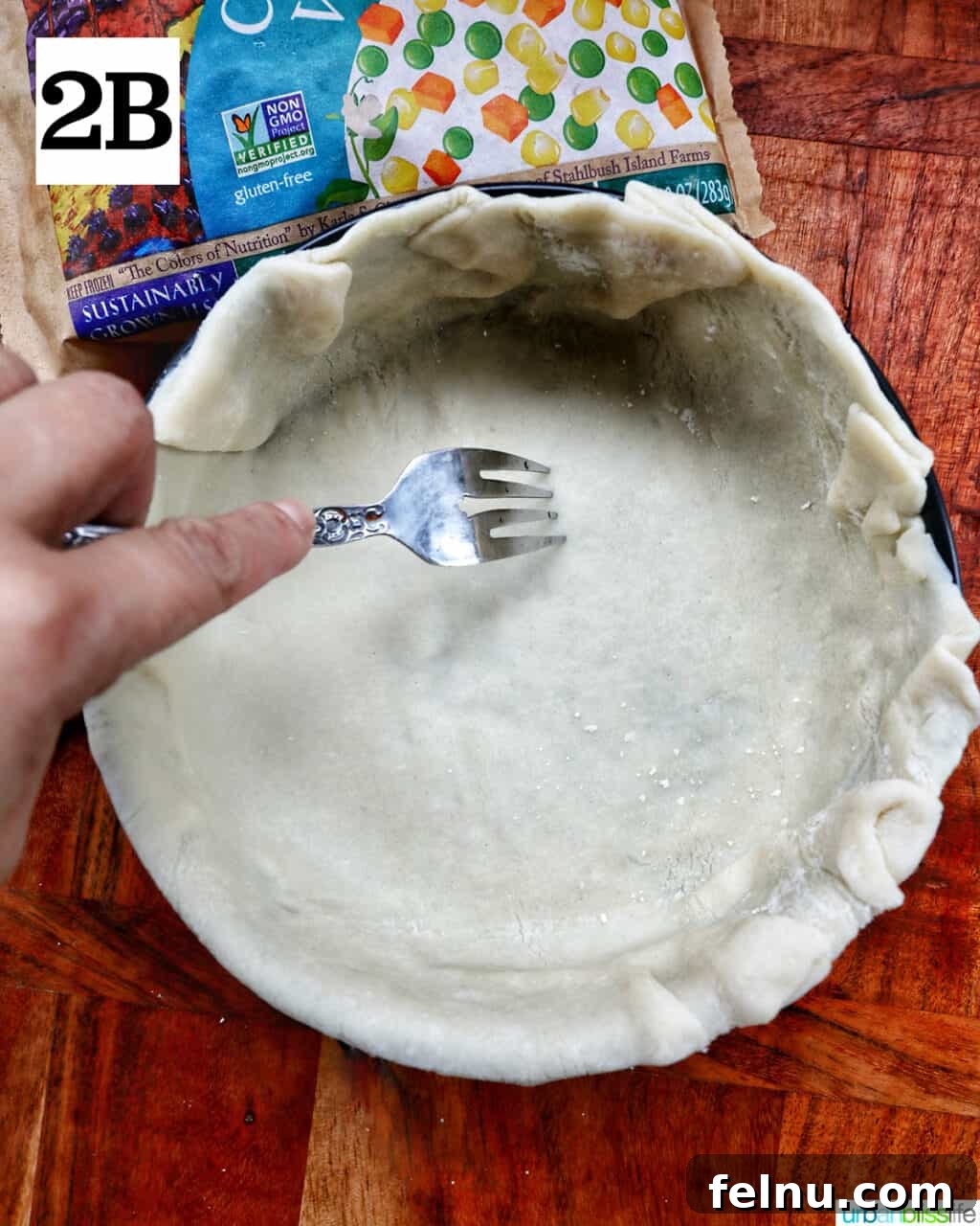 Flaky Air Fryer Chicken Pot Pie 7 hand poking the botto of pie crust with the times of a fork.