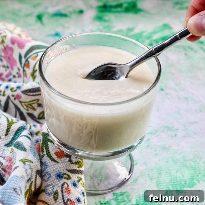 spoon dipped into a parfait bowl with homemade vanilla pudding.