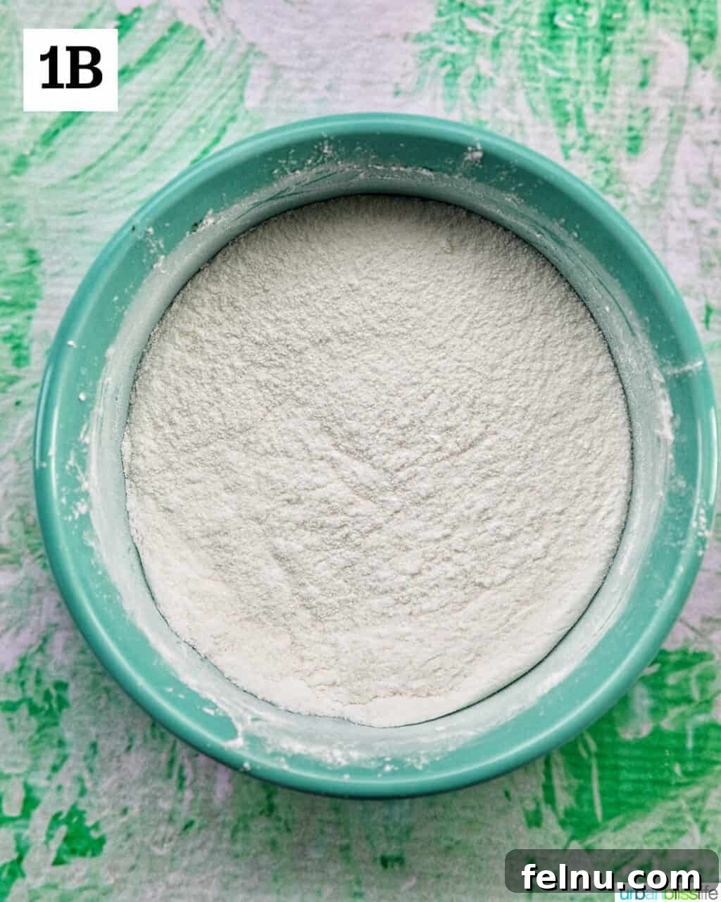 A bowl filled with white powdered ingredients ready to be used for making homemade vanilla pudding.
