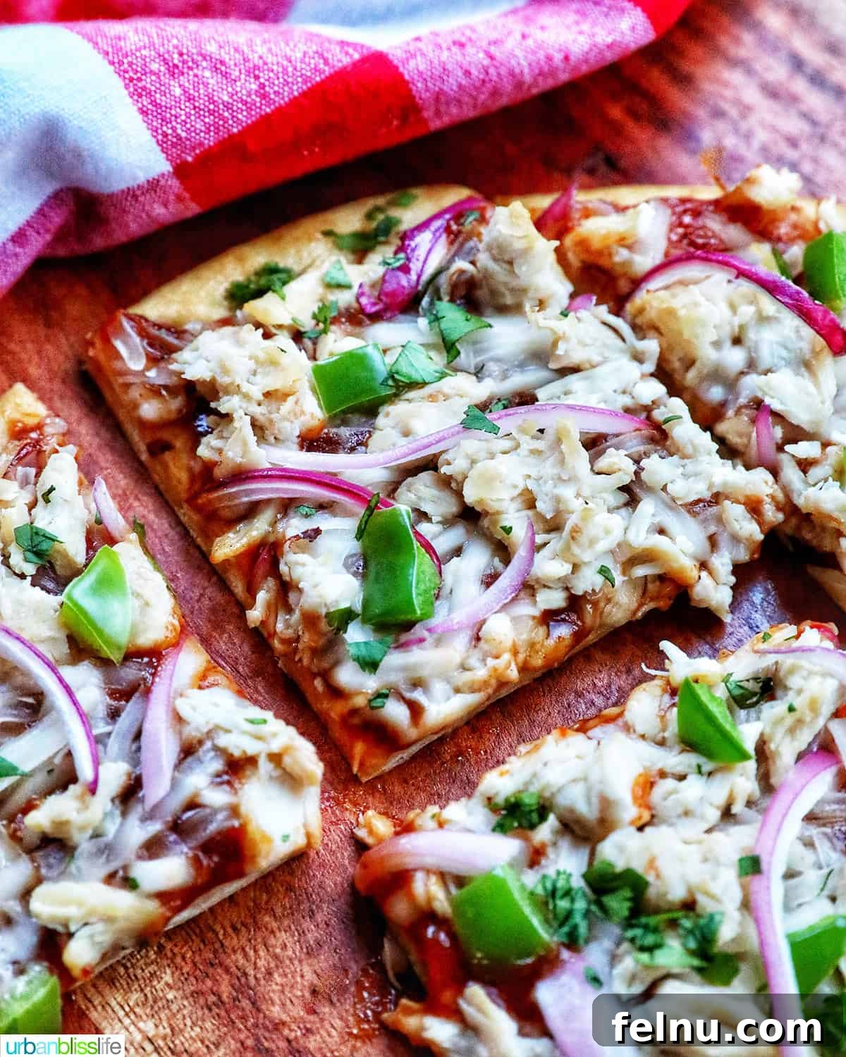 BBQ Chicken Flatbread Feast 2 Delicious BBQ chicken flatbread with red onions, chicken, green peppers, and cilantro, sliced and ready to serve.