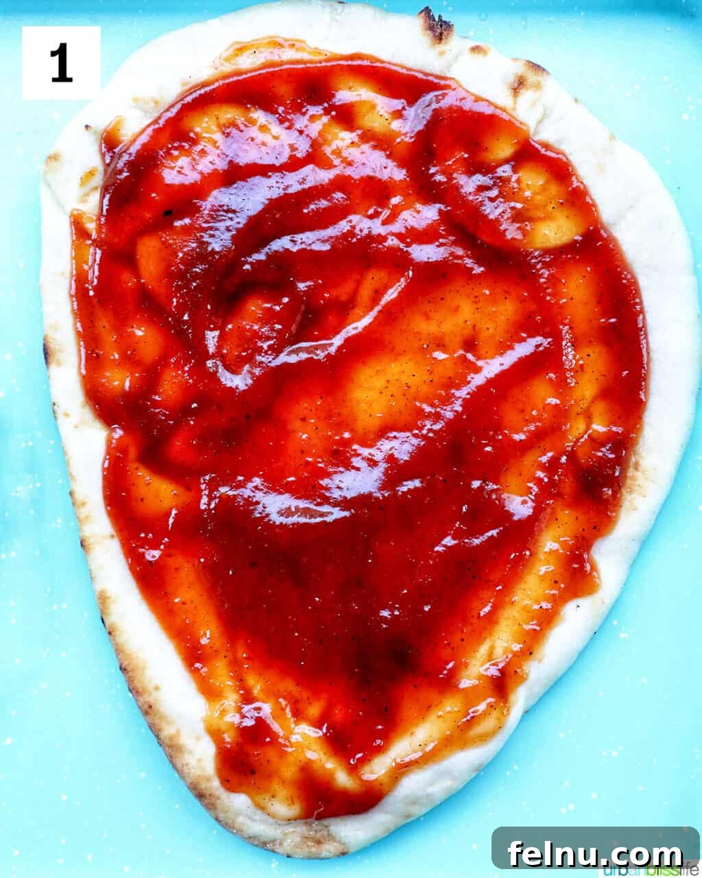 BBQ Chicken Flatbread Feast 5 Applying barbecue sauce to a flatbread.