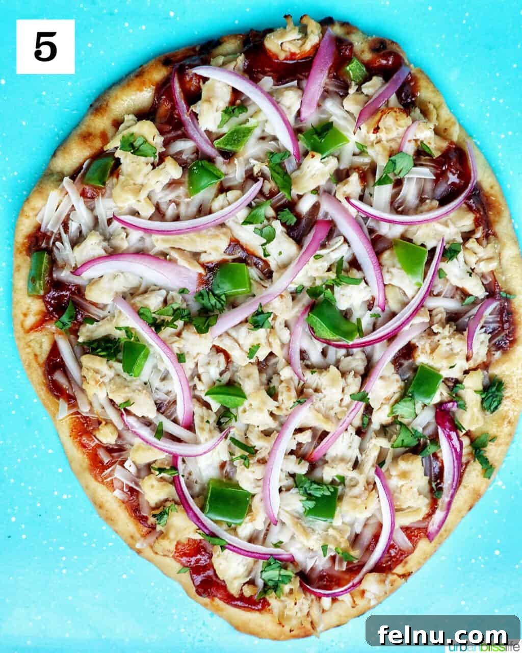 BBQ Chicken Flatbread Feast 9 Baked barbecue chicken flatbread pizza on a blue baking sheet, ready to be served.
