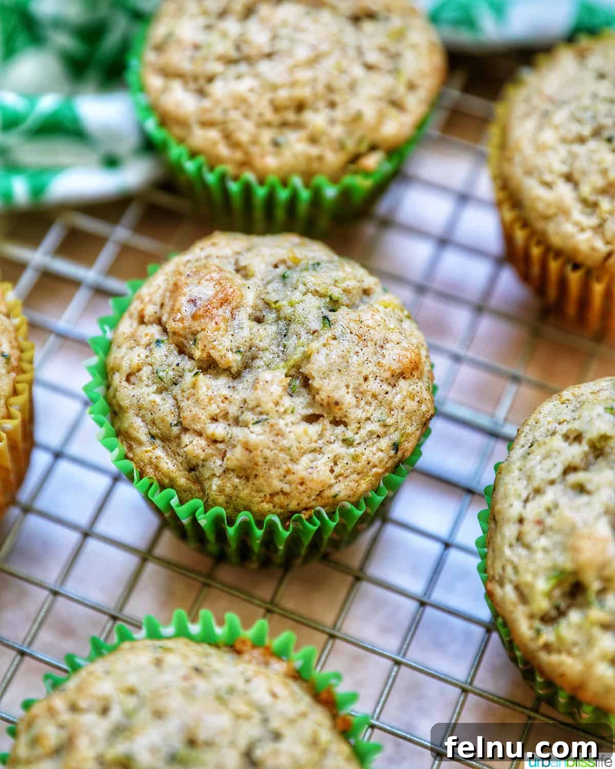 Over 25 Delicious Dairy-Free Muffins 3 Vegan zucchini muffins cooling on a wire rack.