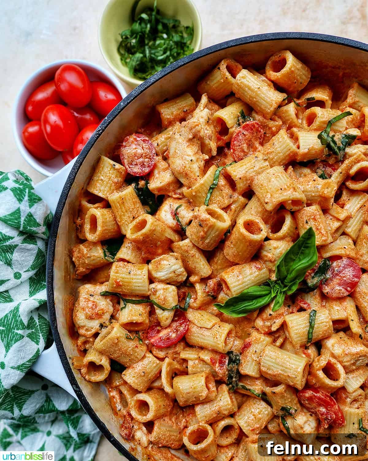 Velvety Tuscan Chicken Pasta 3 Large saucepan filled with rigatoni pasta, creamy Tuscan sauce, chicken, sun-dried tomatoes, and fresh basil.