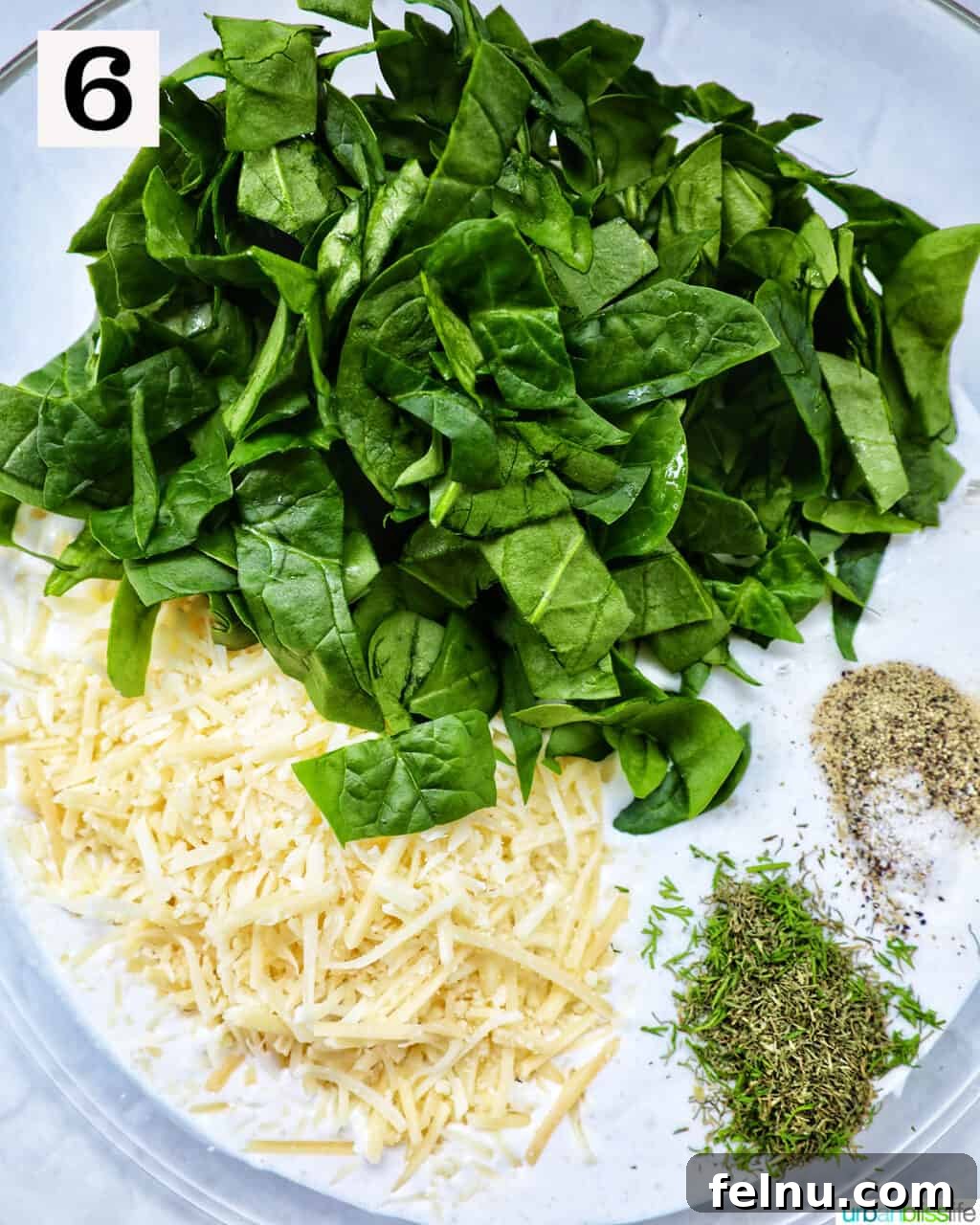 Smoked Salmon & Dill Quiche 12 A mixing bowl filled with fresh baby spinach, shredded cheese, and a medley of herbs and seasonings, waiting for the eggs and cream.
