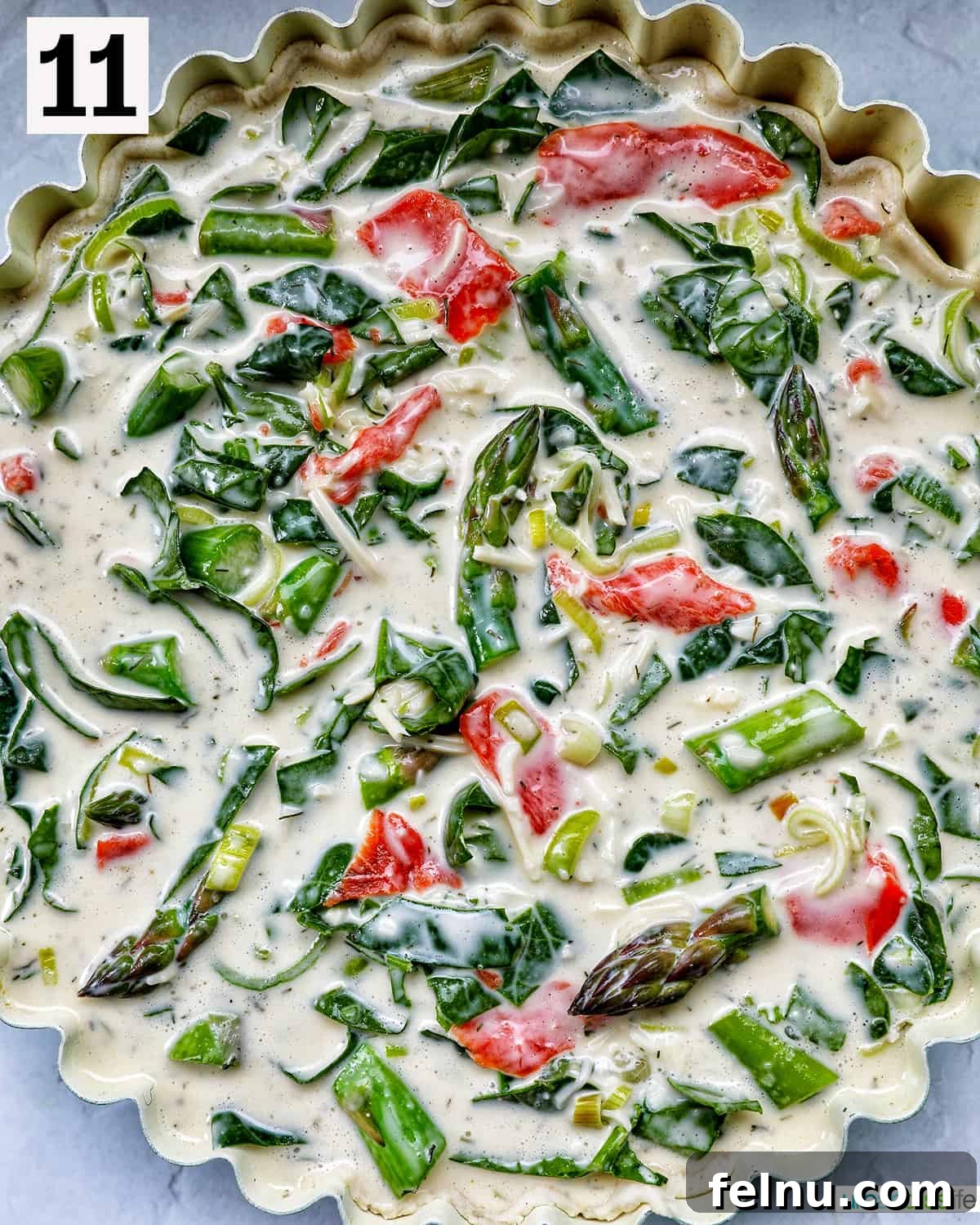 Smoked Salmon & Dill Quiche 18 The fully assembled quiche, featuring the creamy filling, smoked salmon, asparagus, and leeks, nestled in its pie crust, glistening and ready for baking.