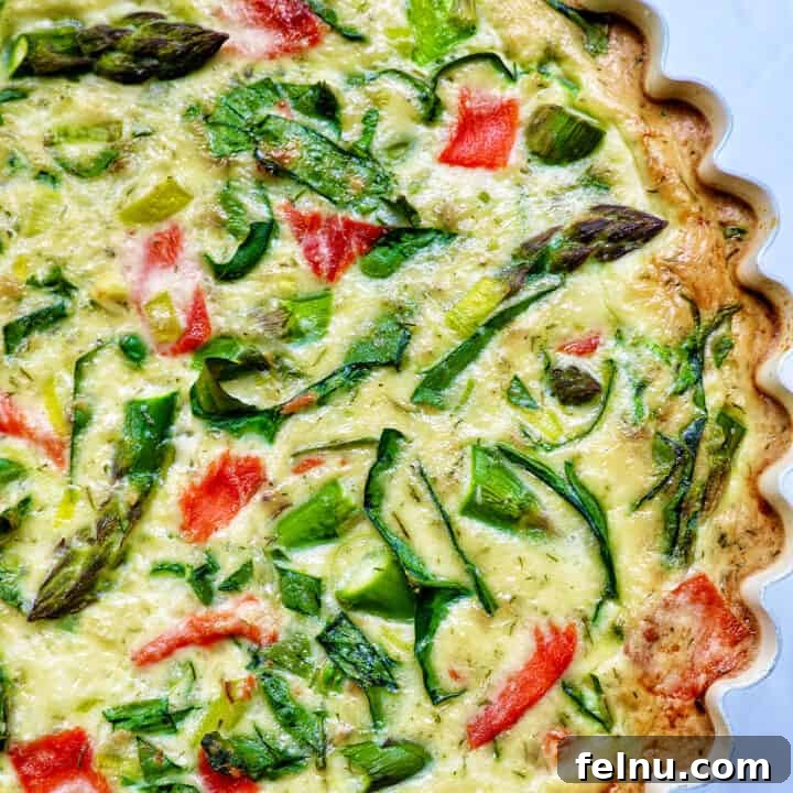 Smoked Salmon & Dill Quiche 22 Half of a quiche in a pie pan with salmon, asparagus, and leeks.