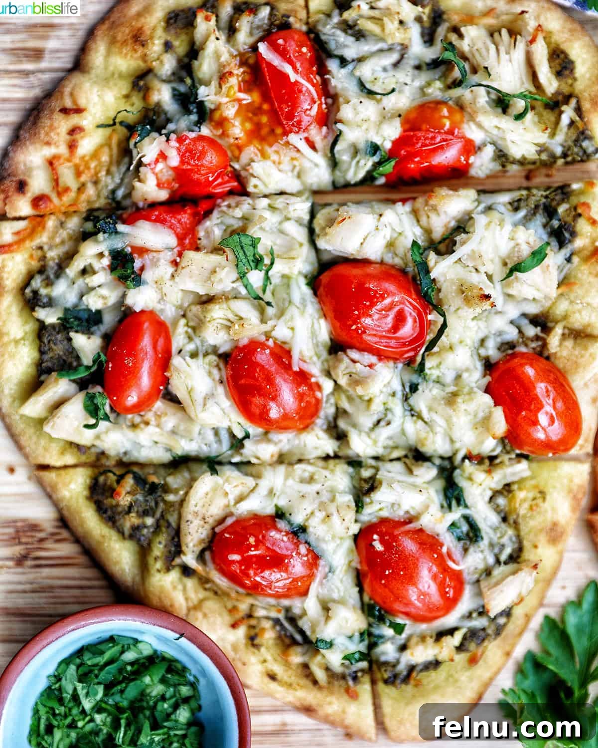 slices of chicken pesto flatbread on a wooden board, ready to be served.