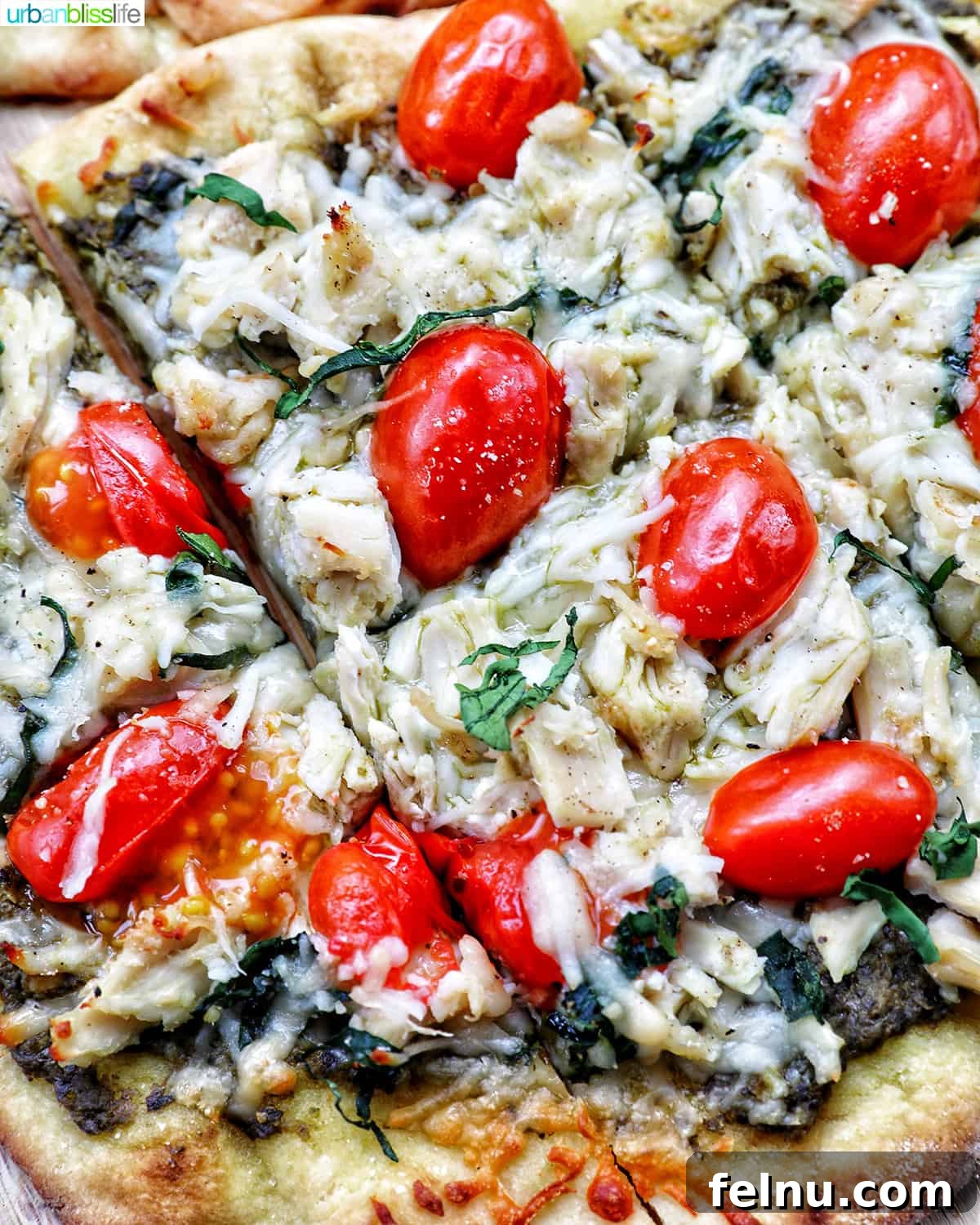 slices of chicken pesto flatbread with tomatoes on a plate, showcasing its vibrant appeal.