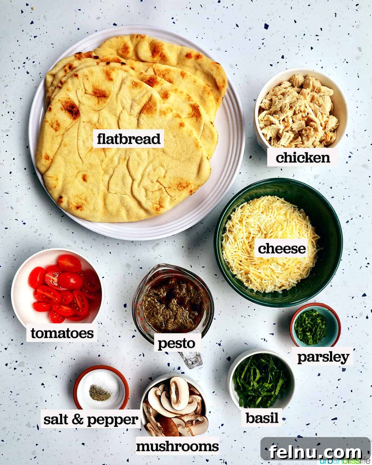 A colorful array of ingredients to make chicken pesto flatbread, with text overlay indicating their purpose.